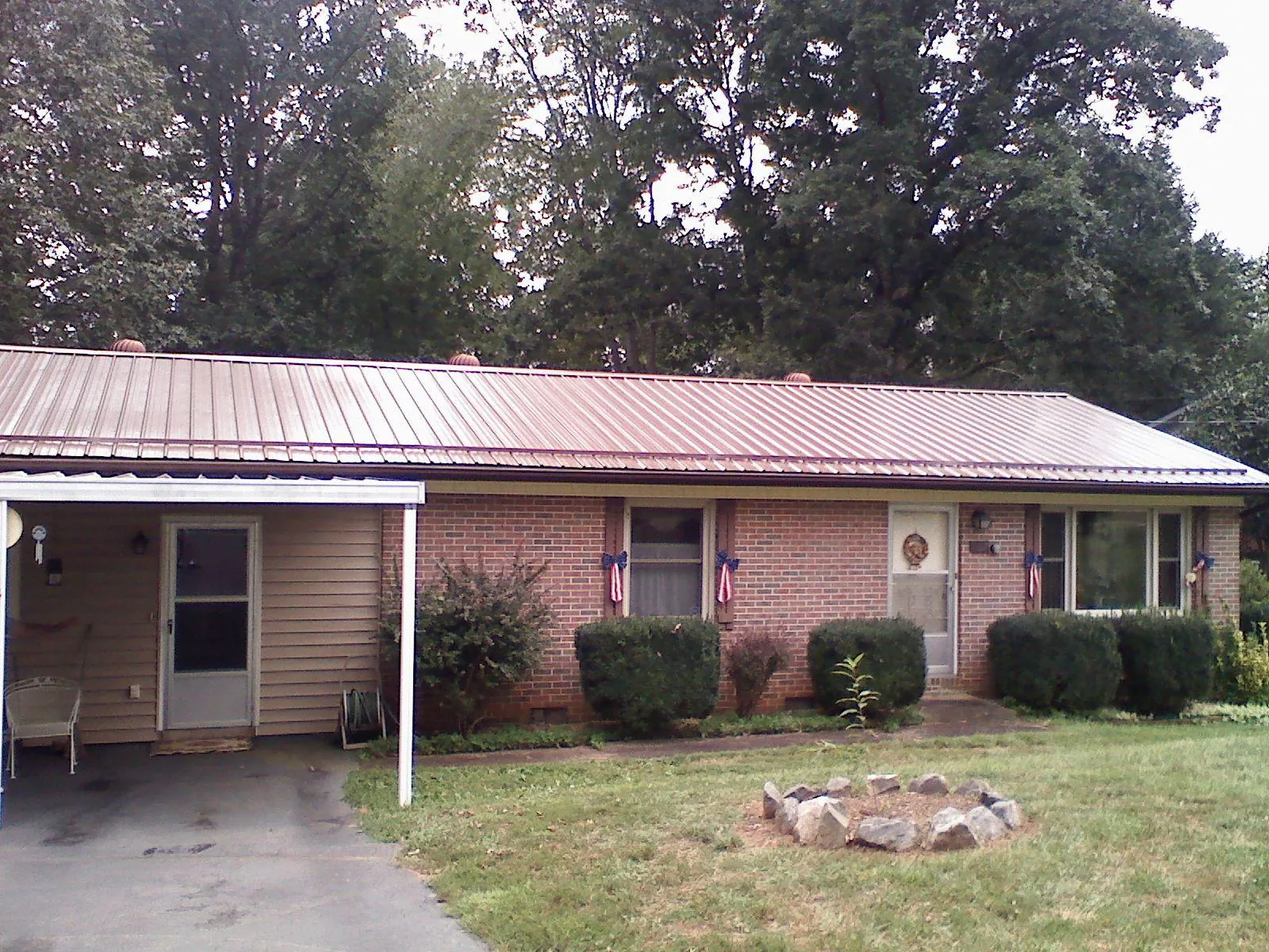 Bronze metal roof and carport on a brick ranch home — Roof Repair work by our crew in Davis
